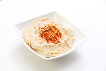 Humus in white bowl, white background