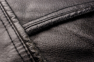 Old vintage genuine soft black leather texture background, top layer with pores and scratches,...