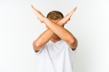 Young caucasian handsome man keeping two arms crossed, denial concept.