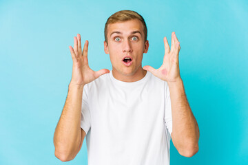 Fototapeta premium Young caucasian handsome man celebrating a victory or success, he is surprised and shocked.
