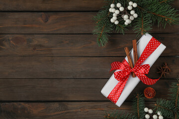 Flat lay composition with white Christmas gift box on wooden table. Space for text