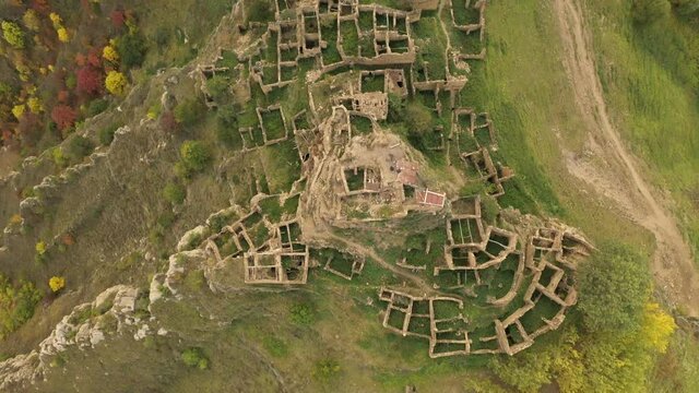 Abandoned in the mountains, the village of Gamsutl. Impregnable hilltop fortress. Ghost town, ruins of an old settlement. 4k aerial view of an ancient abandoned village in the Dagestan mountains
