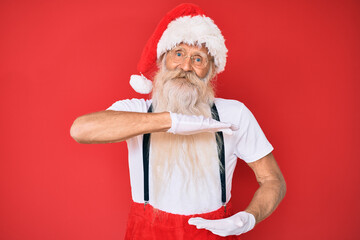 Old senior man with grey hair and long beard wearing white t-shirt and santa claus costume gesturing with hands showing big and large size sign, measure symbol. smiling looking at the camera.