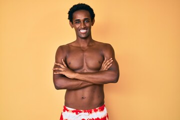 Fototapeta premium African handsome man wearing swimsuit happy face smiling with crossed arms looking at the camera. positive person.