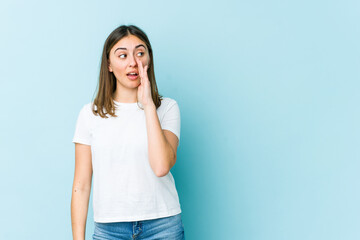 Young caucasian woman is saying a secret hot braking news and looking aside