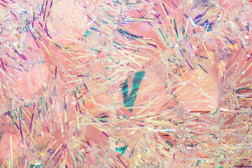 Christmas tinsel garland in Peach Fuzz color. Abstract iridescent pink background. Pastel New Year backdrop or texture.