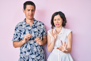 Beautiful couple wearing casual clothes disgusted expression, displeased and fearful doing disgust...