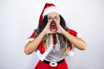 Young beautiful woman wearing a Santa Claus costume over white background shouting and screaming loud to side with hands on mouth