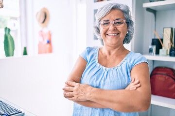 Fototapeta premium Middle age shop assistance woman working at the counter of retail shop smiling happy