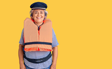 Senior woman with gray hair wearing nautical lifejacket looking positive and happy standing and smiling with a confident smile showing teeth