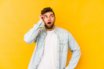 Young caucasian man isolated on yellow background being shocked, she has remembered important meeting.