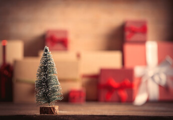 Little Christmas tree and gift boxes on background