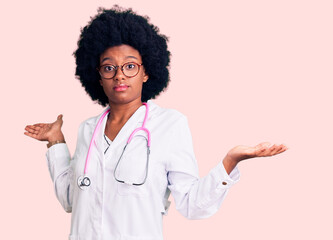 Young african american woman wearing doctor coat and stethoscope clueless and confused expression...