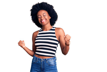 Young african american woman wearing casual clothes very happy and excited doing winner gesture with arms raised, smiling and screaming for success. celebration concept.