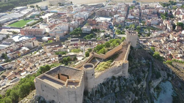 View from drone of houses and old castle of town of Castalla at sunny day, Alicante, Spain
