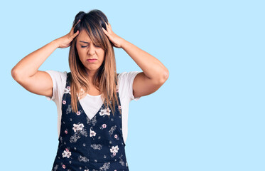 Young beautiful woman wearing casual floral dress suffering from headache desperate and stressed...
