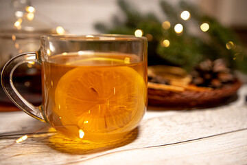 
a cup of hot Christmas tea with lemon on a light wood. against the background of an asterisk star...