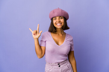 Young mixed race woman showing a horns gesture as a revolution concept.