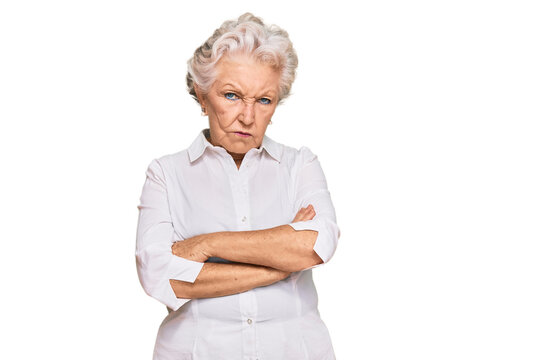Senior grey-haired woman wearing casual clothes skeptic and nervous, disapproving expression on face with crossed arms. negative person.