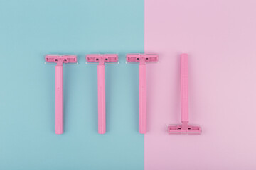 Close up of pink razors for shaving on blue and pink background