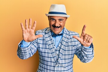 Mature middle east man with mustache wearing vintage and elegant fashion style showing and pointing up with fingers number seven while smiling confident and happy.