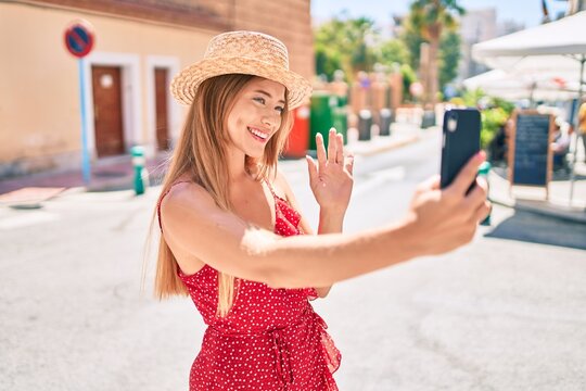 Young caucasian tourist girl smiling happy doing video call using smartphone at the city.