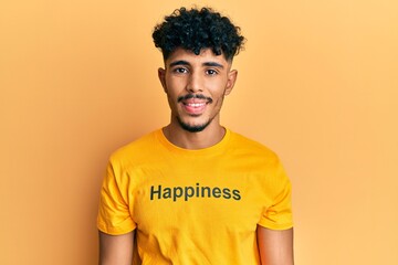 Fototapeta na wymiar Young arab handsome man wearing tshirt with happiness word message with a happy and cool smile on face. lucky person.
