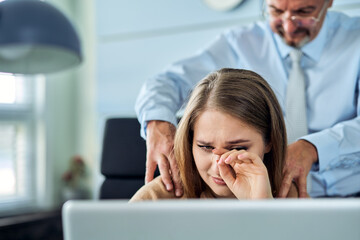 Harassment with a boss touching the arm to his secretary who is sitting in his workplace at office