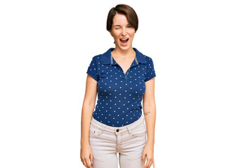 Fototapeta premium Young brunette woman with short hair wearing casual clothes winking looking at the camera with sexy expression, cheerful and happy face.