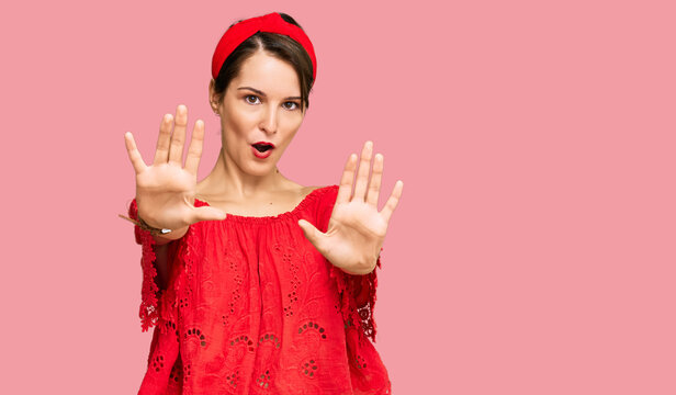 Young brunette woman with short hair wearing casual summer clothes and diadem doing stop gesture with hands palms, angry and frustration expression