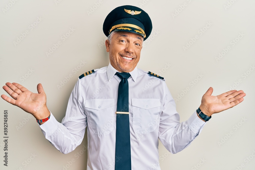 Sticker Handsome middle age mature man wearing airplane pilot uniform smiling showing both hands open palms, presenting and advertising comparison and balance