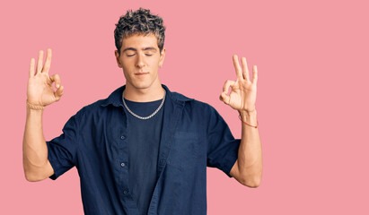 Young handsome man wearing casual clothes relax and smiling with eyes closed doing meditation gesture with fingers. yoga concept.