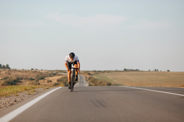 Obraz premium Young guy in activewear biking fast on paved road
