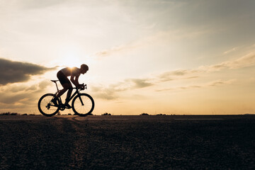 Side view of sportsman in protective helmet riding bike - obrazy, fototapety, plakaty