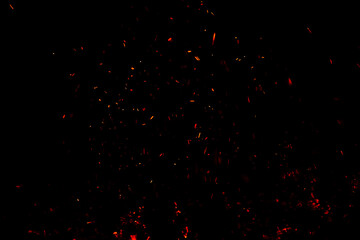 Burning red hot sparks rise from large fire in the night. Fire flames sparks background. Abstract...