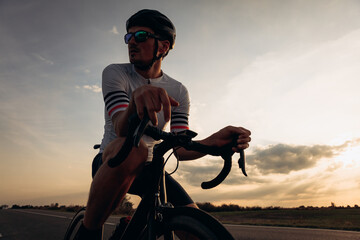 Cyclist in helmet and eyewear taking break outdoors
