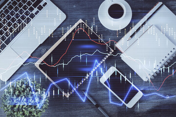 Double exposure of forex chart hologram over desktop with phone. Top view. Mobile trade platform concept.