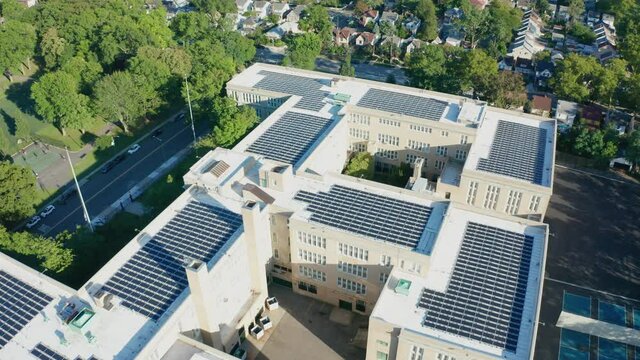 Aerial Drone Shot Flying Over a Large PV Solar Installation on Bayside HS Roof