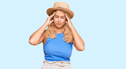 Obraz na płótnie Canvas Young blonde girl wearing summer hat suffering from headache desperate and stressed because pain and migraine. hands on head.