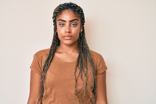 Young African American Woman With Braids Wearing Casual Clothes With Serious Expression On Face. Simple And Natural Looking At The Camera.