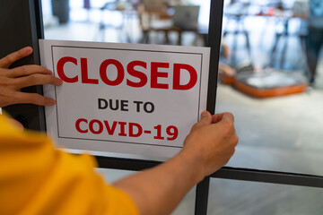 Business center closed due to COVID-19, sign with sorry in door window. Stores, restaurants, offices, other public places temporarily closed during coronavirus pandemic. Economy hit by corona virus.