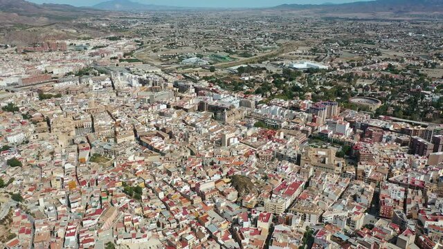 Aerial view of Spanish city of Lorca overlooking Collegiate church of St. Patrick and ancient castle on hilltop on sunny autumn day. High quality 4k footage
