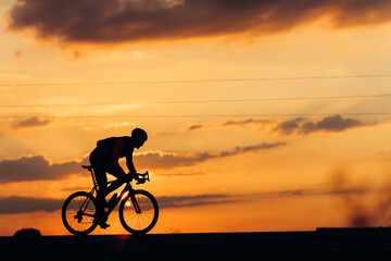 Obraz premium Side view of professional cyclist training on paved road