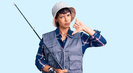 Young brunette woman with short hair wearing fisherman equipment with angry face, negative sign...