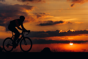 Sporty man in activewear cycling on paved road