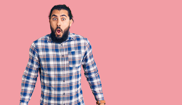 Young arab man wearing casual clothes afraid and shocked with surprise expression, fear and excited face.