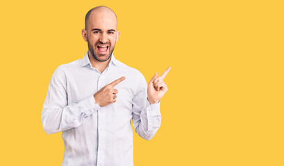 Young handsome man wearing elegant shirt smiling and looking at the camera pointing with two hands and fingers to the side.