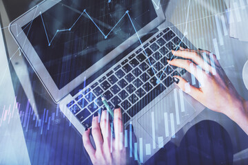 Double exposure of woman hands working on computer and forex chart hologram drawing. Top View....