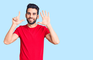 Fototapeta premium Young handsome man with beard wearing casual t-shirt showing and pointing up with fingers number seven while smiling confident and happy.