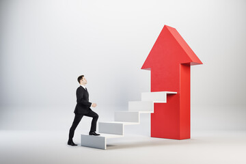 Businessman climbing on concrete stairs with red arrow.